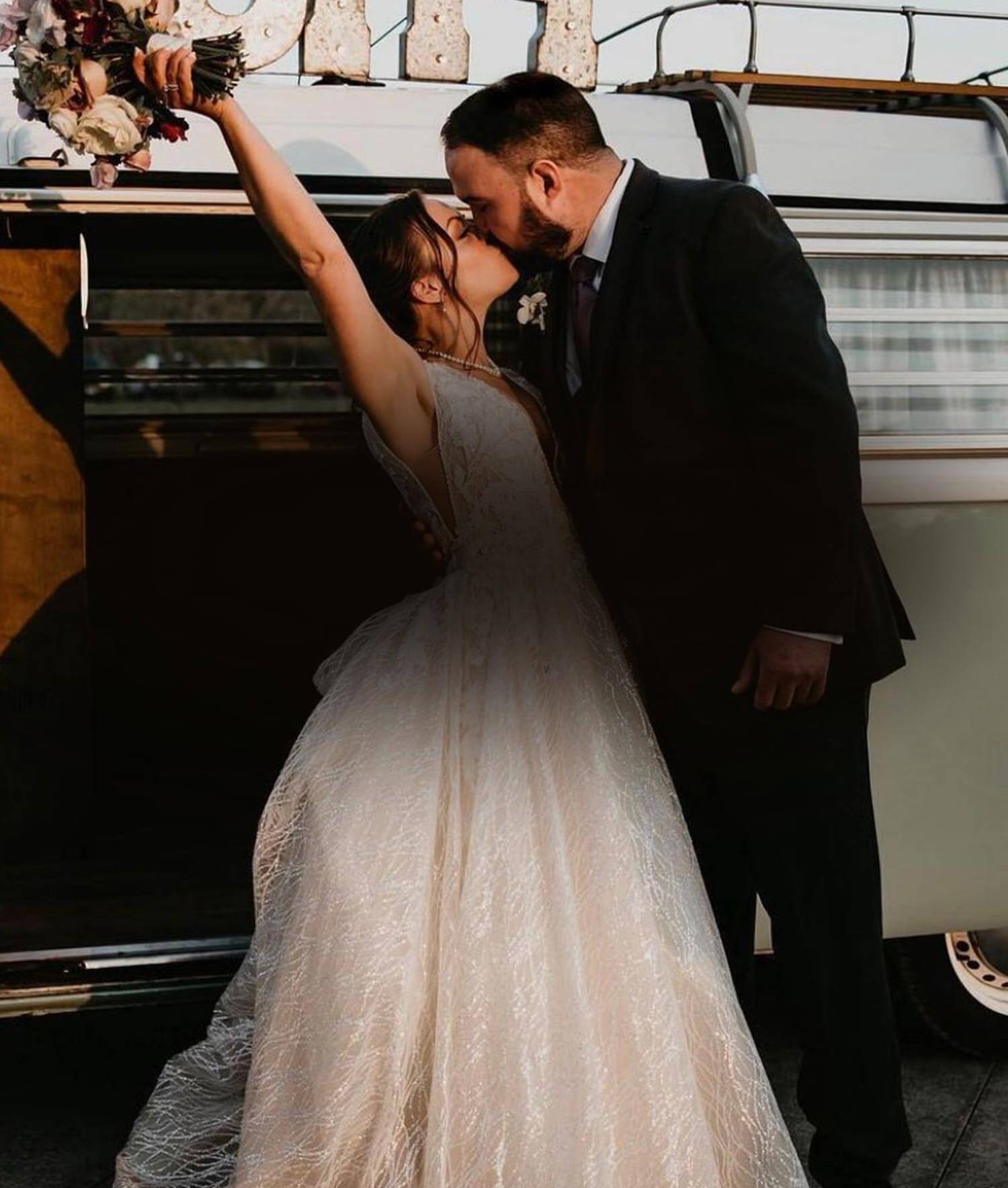 Сouple wearing a white gown and a black suit. Mobile image